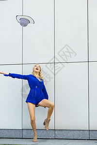 穿着蓝色跳衣的快乐女人玩得开心扔了太阳帽时装模特和暑假服时模特图片