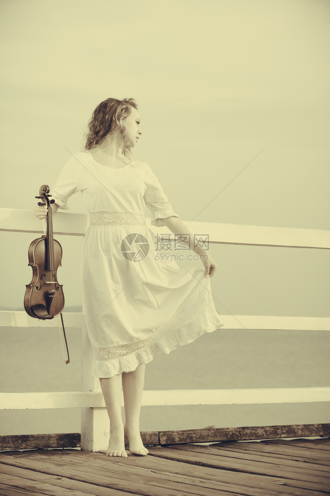 音乐爱好和日常激情概念落时在码头外的妇女拿着小提琴在码头外的妇女拿着小提琴图片