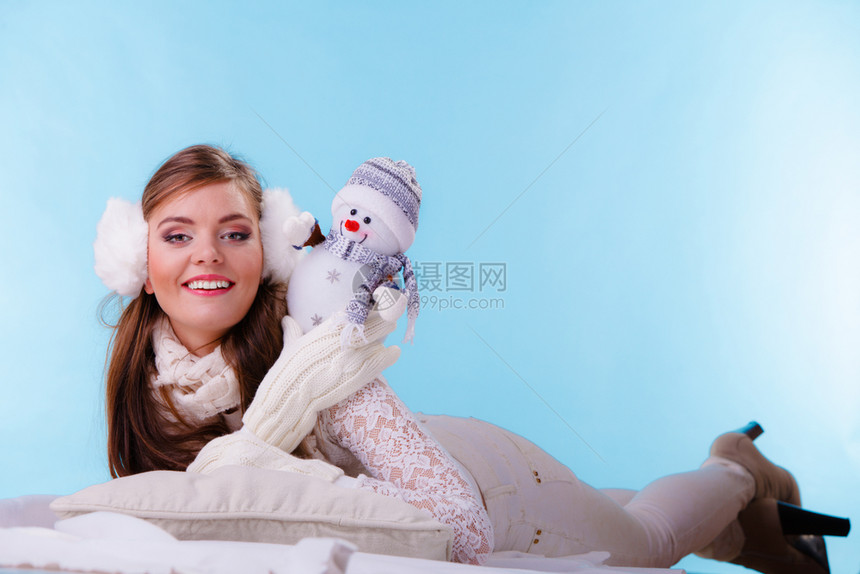 穿着耳毛和白色衣的可爱女孩在工作室穿蓝色冬天时装可爱的女人图片