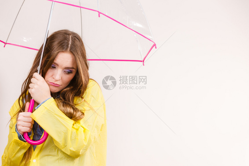 身着防水黄色大衣被冻在透明伞下身着黄大衣雨淋的女子图片