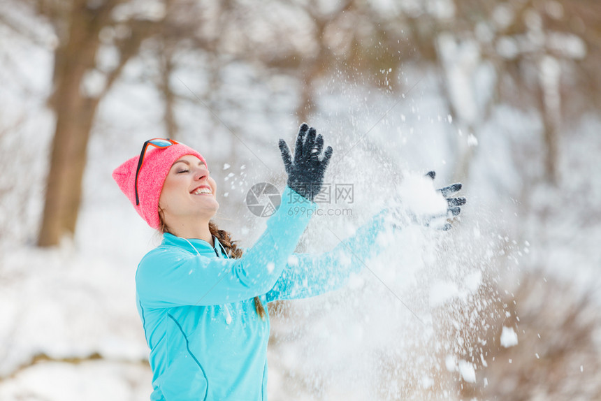 在冬季公园放松的年轻女健康自然的时装身概念女孩在周围吹雪图片
