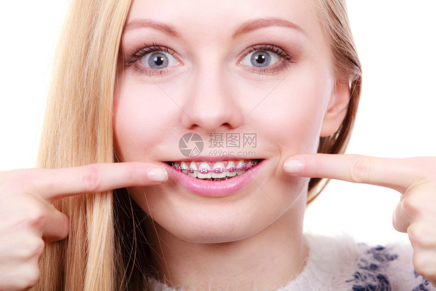 快乐的女士在牙齿上指着她的套快乐女士在牙齿上展示她的套图片