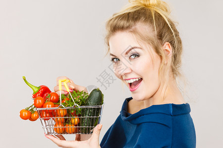 好物推荐购买好食品素产积极的女在室内用绿色红蔬菜持有购物篮建议健康高纤维饮食改变生活方式在灰色上购买妇女用蔬菜持有购物篮背景