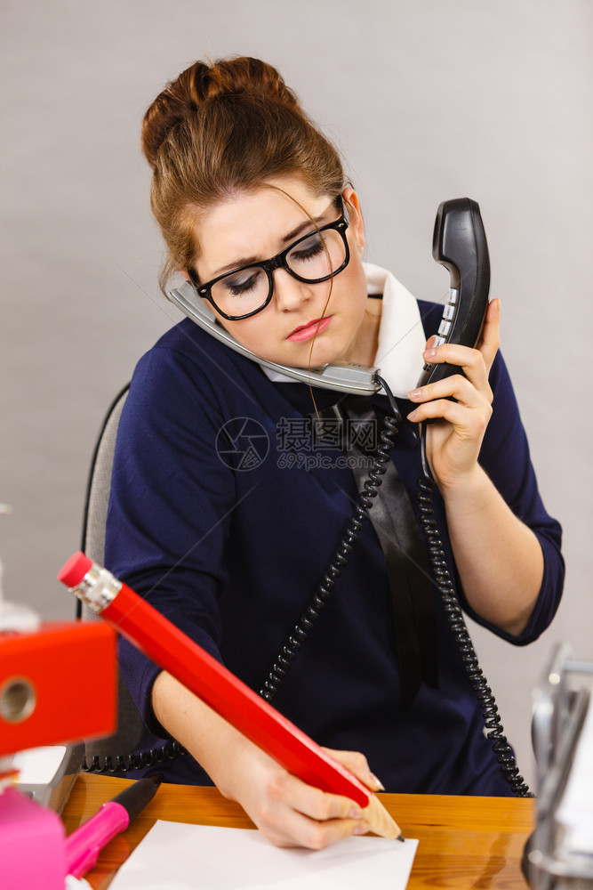睡不着的女商人在办公桌上工作坐在办公桌里工作全坐在文件架上工作无聊地在电话上说图片