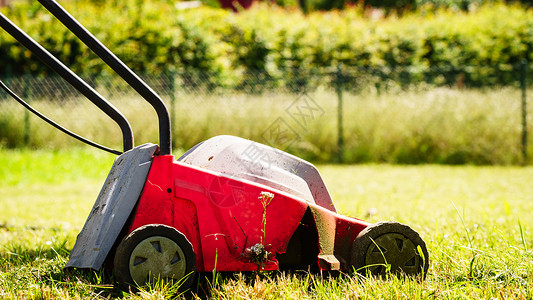 园艺服务旧割草机在后院砍伐绿草场阳光明媚的日间用割草机修剪场用坪修剪用割机修剪坪背景图片