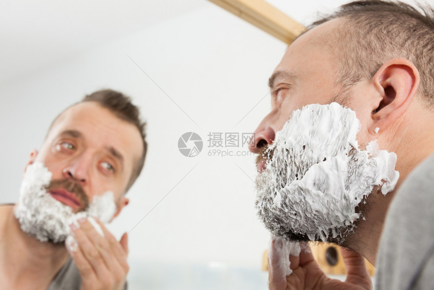 男人在修剪胡子前准备面部毛发应用剃须奶油泡沫糖男美容治疗概念男人在剪胡子前涂剃须膏图片