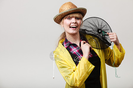 骑着空渔网玩得开心骑着空渔网的黄雨衣快乐女人高清图片