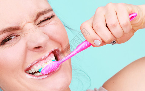 女人刷牙缝合口腔卫生蓝绿色背景妇女刷牙图片