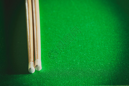 Billiards球杆在绿桌上池球游戏棍在绿色台桌上背景图片