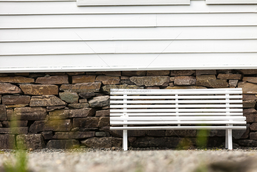 对称的白色长凳在传统的有窗户扫描型木制轻房屋前图片