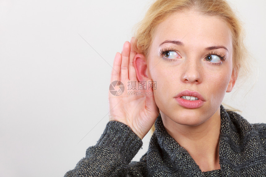 手势流言听力丧失或混乱妇女为更好的听力而亲手倾工作室在浅灰色后脑中拍摄图片