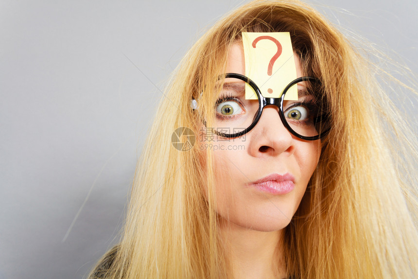 身着书呆子眼镜的疯女人在紧张思考前额有问题标记和头发乱之后精疲力尽图片