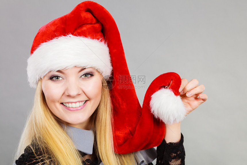 戴圣诞老人帮手帽子的快乐妇女图片