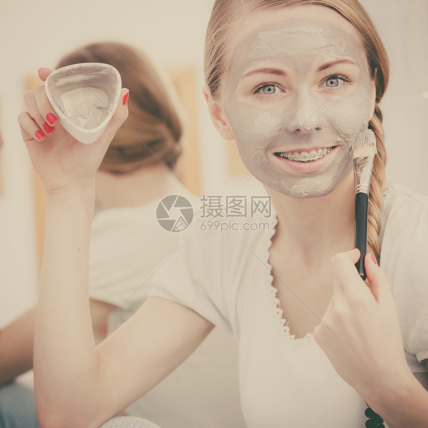 皮肤科在浴室的金发女人脸上戴灰泥面罩照顾皮肤的年轻女士斯帕美容过滤照片脸上戴灰泥面罩的妇女图片