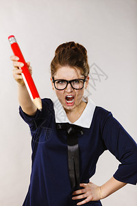 愤怒的女学生或教师拿着大红铅笔尖叫的愤怒女学生或教师图片