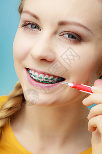 使用小牙刷中间笔牙的年轻女使用中间笔刷牙的妇女高清图片