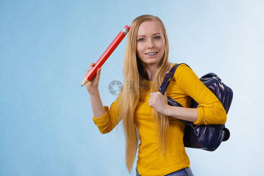 带着背包和拿大铅笔去上学或大的金发少女快乐的年轻金发女孩图片