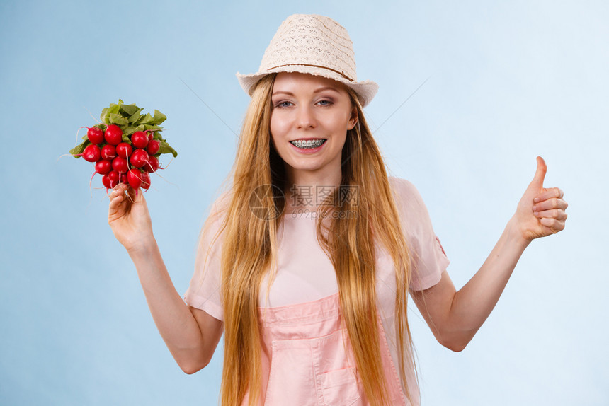 快乐的年轻少女准备过暑假穿着粉红色服装戴着美味萝卜的太阳帽图片
