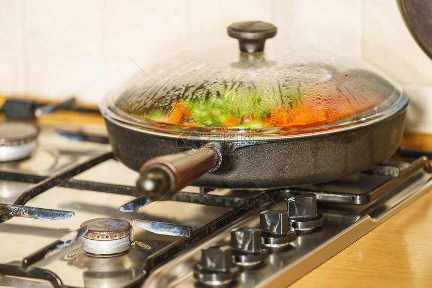 许多人在煎锅上切开健康的蔬菜素食烹饪图片