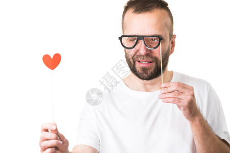 男人拿着心形和眼镜在棍子上取笑带着眼镜和心的人图片