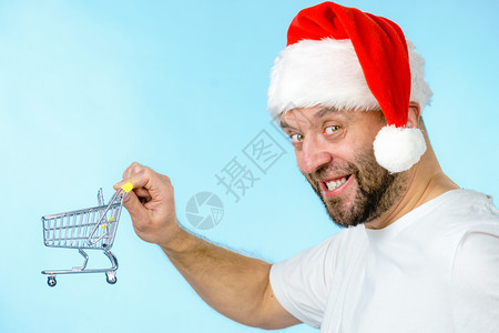 穿着圣达克萨斯帽子的人拿着空购物篮车圣诞节季节销售拳击日概念图片