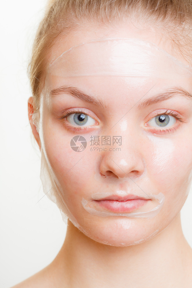 脸部剥皮的年轻女面部剥皮的年轻女肤美容和护理工作室拍摄灰色图片