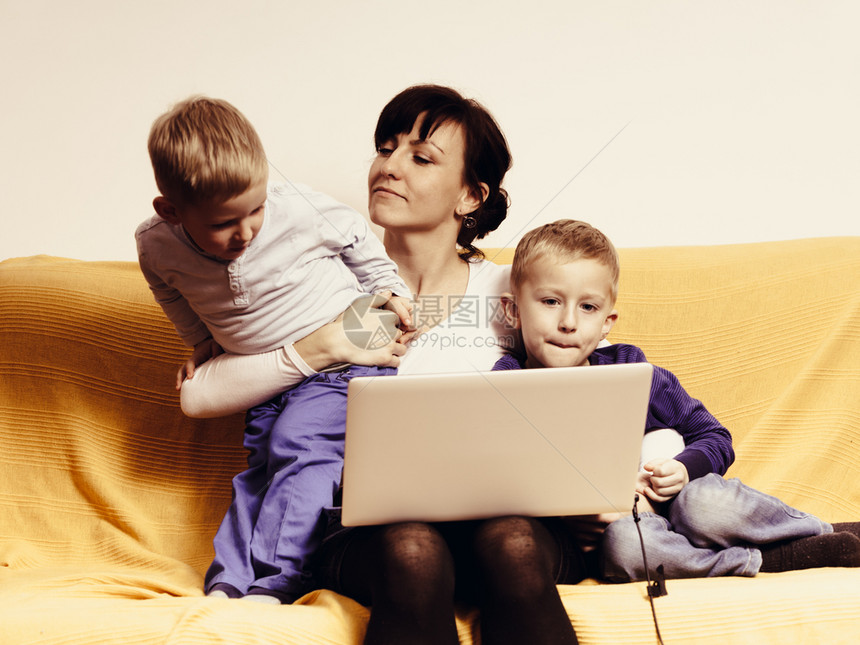 两个小男孩和母亲使用笔记本电脑看影和玩乐两个小男孩和母亲使用笔记本电脑图片