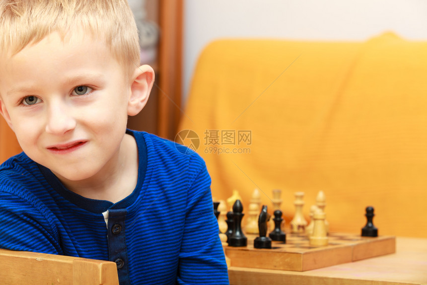 聪明的孩子对大脑智能概念有好处的游戏年轻男孩玩象棋和得开心象棋的年轻男孩玩得开心图片