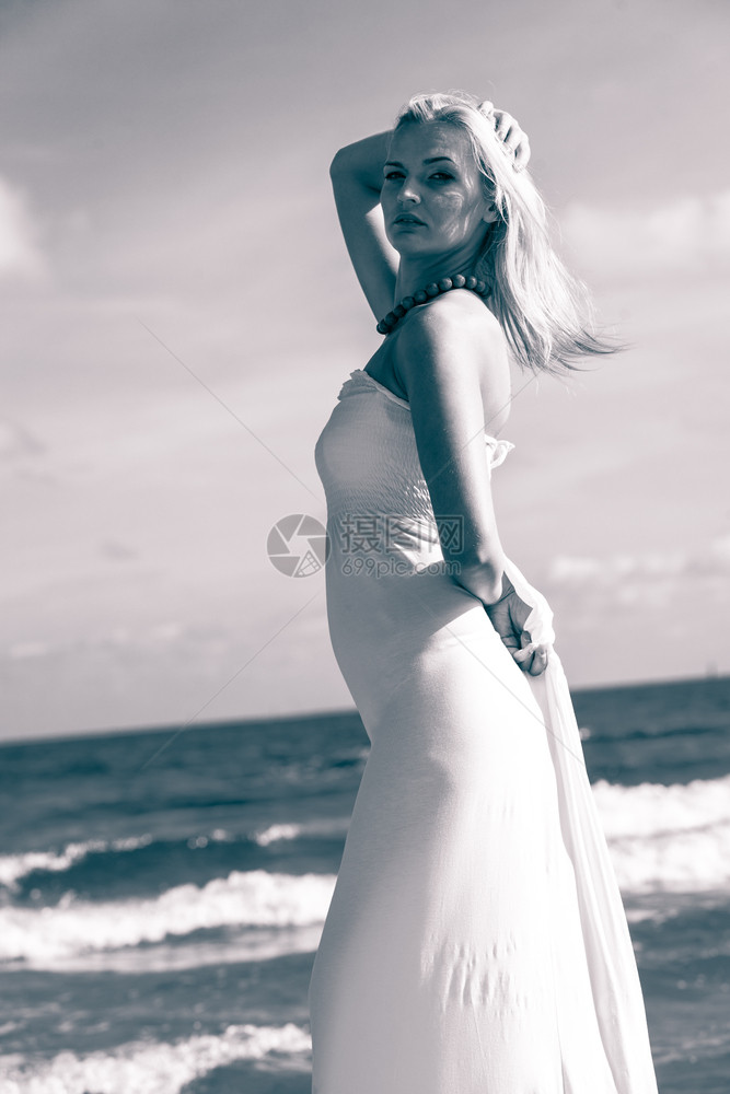 阳光明媚的海滩上美丽女人站在海上的年轻女孩自然户外放松休闲概念图片