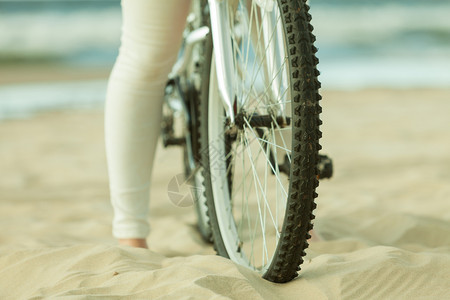在沙滩上骑自行车的女人图片