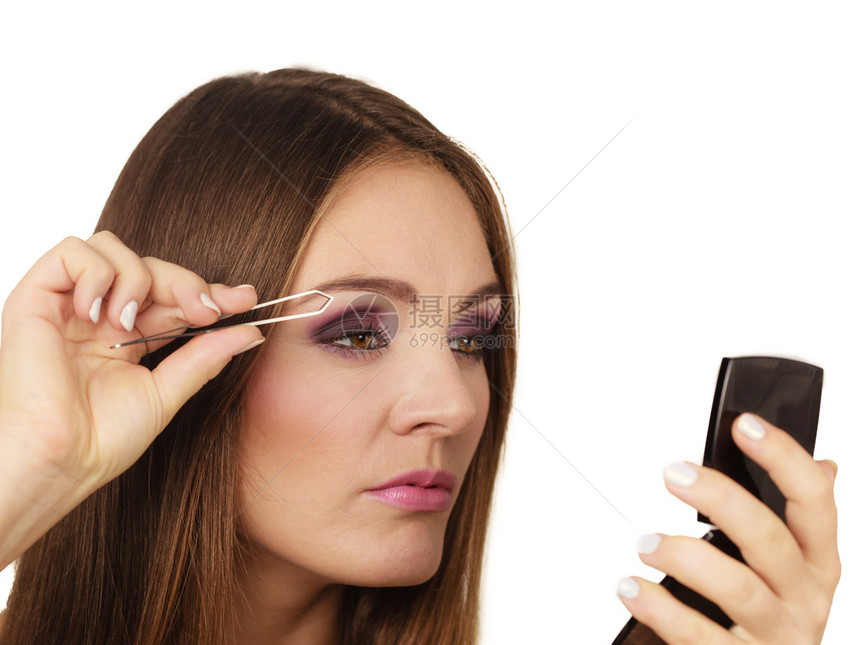 化妆品和女人拿眉毛和树枝女孩拿眉毛看镜子图片