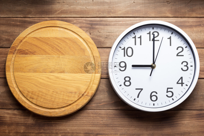 木制背景纹理时钟和披萨切面板图片