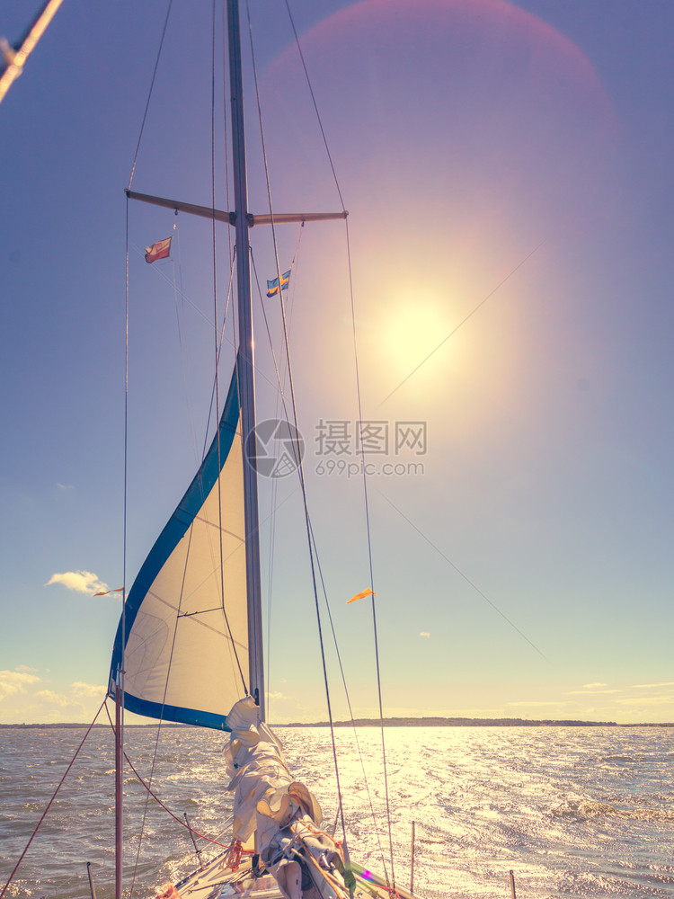 在阳光明媚的夏季天气中乘帆船在平静的蓝色海水上游乘帆船图片