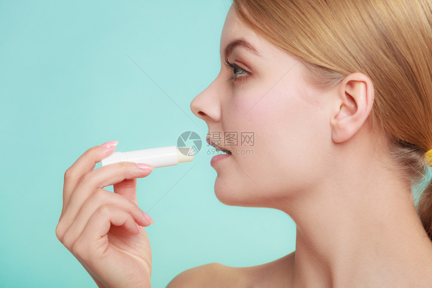 女用嘴唇上润滑的balsam照顾嘴唇的女孩皮肤科用巴萨的嘴唇图片