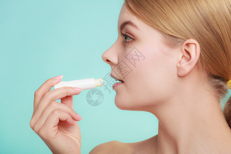 女用嘴唇上润滑的balsam照顾嘴唇的女孩皮肤科用巴萨的嘴唇图片