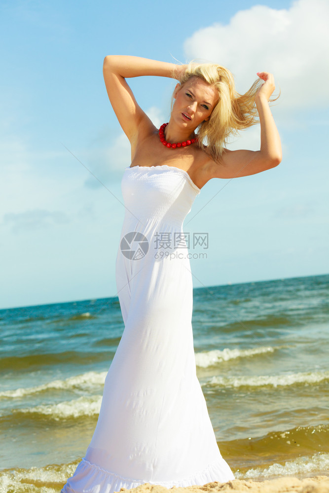穿着白裙子的年轻优雅女人户外休闲放松概念女孩在岸上散步图片