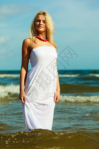 闲暇时间活动年轻女人在沙滩上冷却女士在外面闲逛迷人女孩有白裙子图片