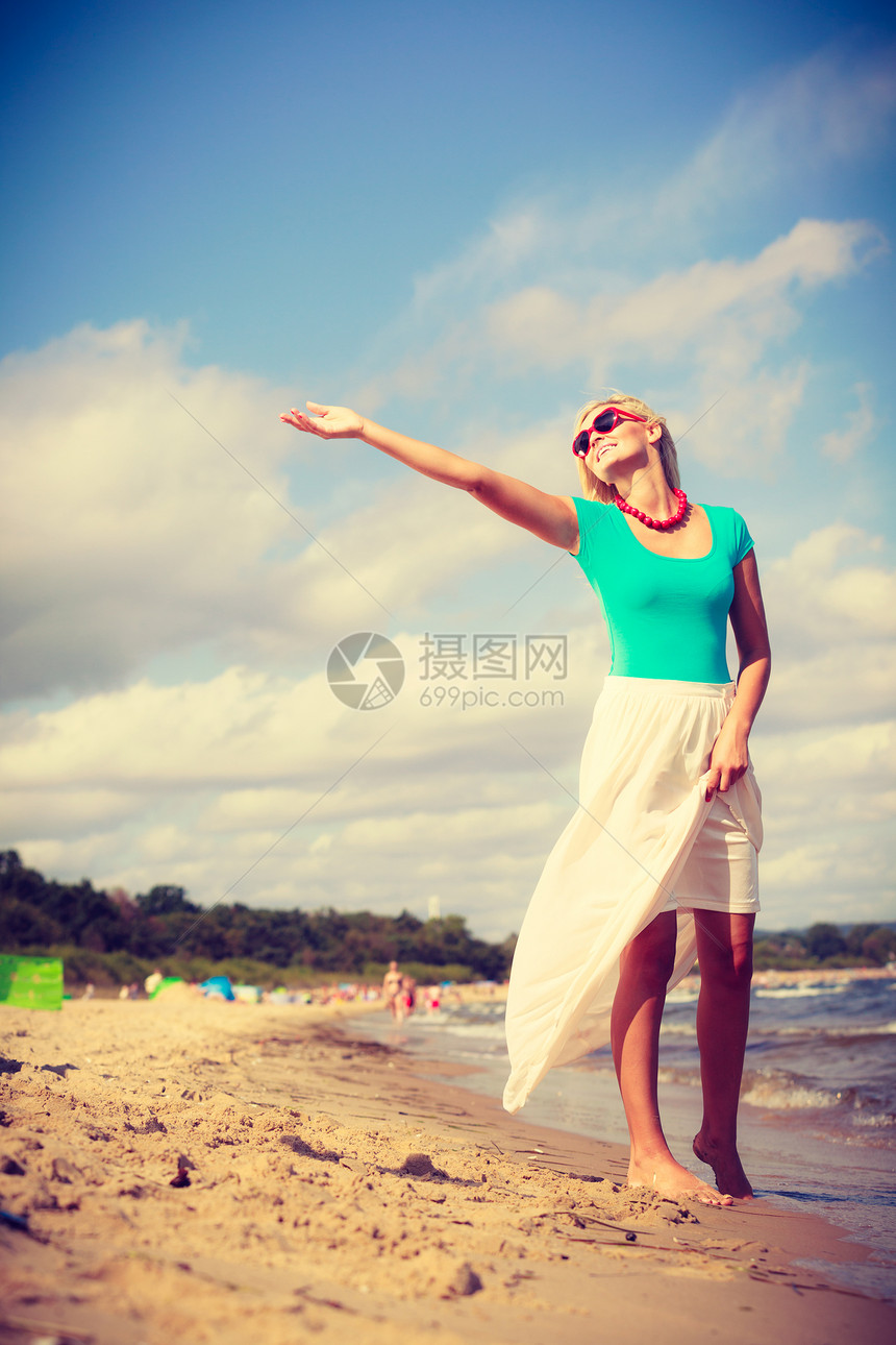 夏假放松休闲概念海滩上迷人的女戴墨镜士在阳光明媚的白天玩得开心图片
