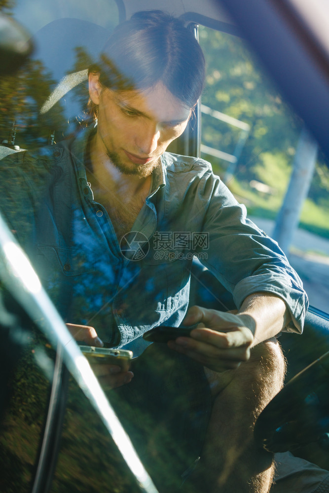现代技术概念人驾驶汽车时使用移动电话检查社交媒体或设置导航前视人驾驶汽车时使用手机图片