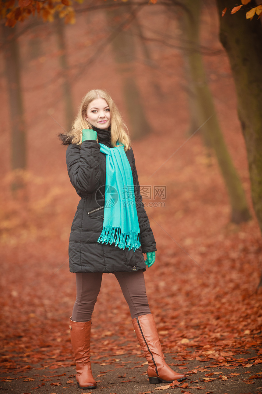 露天休闲树叶植被概念微笑的女士走过公园年轻的金发美女穿着蓝围巾在秋天林地散步微笑的女士走过公园图片