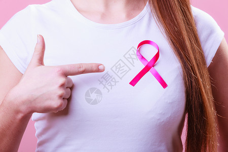 保健医药和乳腺癌认识概念关闭妇女胸前的粉色章丝带以支持乳腺癌的原因关闭妇女胸前的粉色丝带以支持乳腺癌的原因背景图片