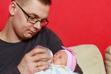 父亲抚养和照顾新生儿用瓶子喂奶父亲用瓶子喂奶图片