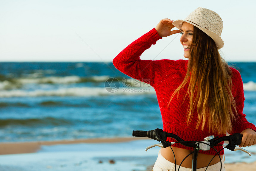 在海边骑自行车的年轻女子图片