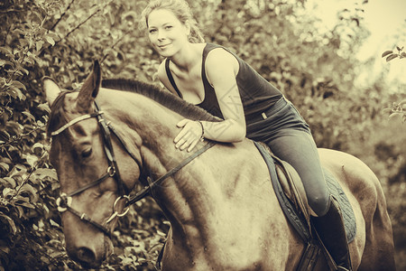 骑马的动物理念坐在上抱的年轻女人塞皮亚拥抱和坐在马上的年轻女人图片
