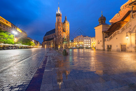 波兰克拉科夫旧城中世纪主要市场广上的圣玛丽巴西利卡雨夜主市场广背景图片