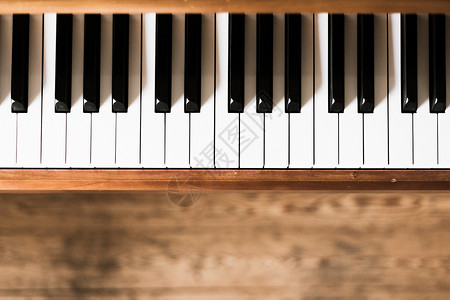 原始木制钢琴前景的钥匙模糊背景的木制地板图片