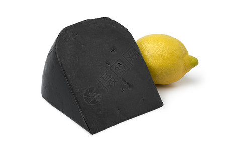 一块黑色柠檬奶酪和白色背景的新鲜黄柠檬图片