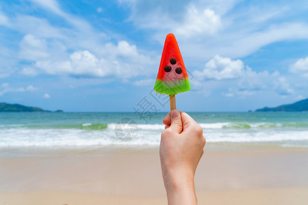 西瓜海洋在泰国普吉中午的海洋或自然旅行度假室外游渡期间在海滩上手握西瓜冰淇淋的妇女手背景