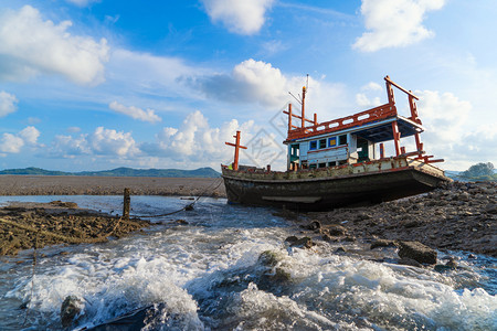 泰国普吉市海岸的一艘旧船难或废弃渔有瀑布和蓝天背景图片