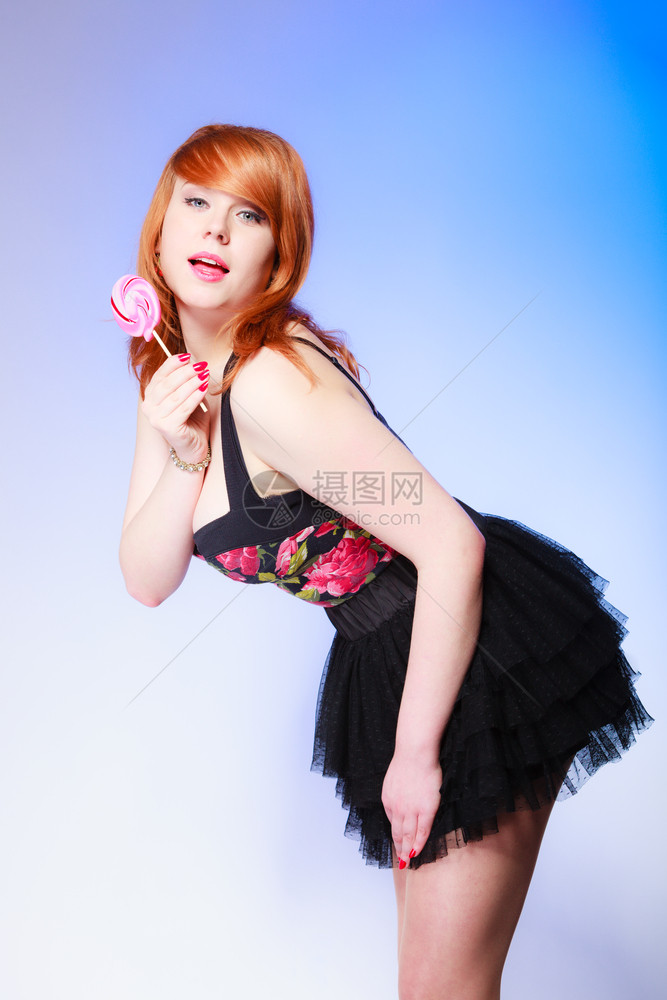 拿着糖果的感年轻女人红发可爱孩蓝着甜棒糖的红发可爱女孩图片